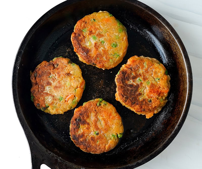 Pan fried fish cake patties in a pan