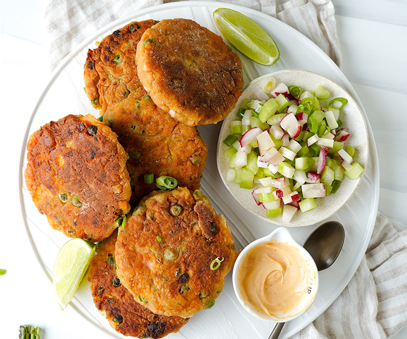 Salmon cakes with aioli and salad on a plate