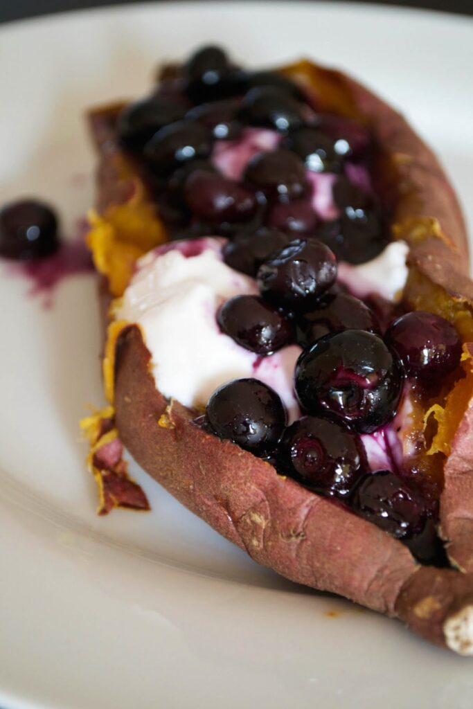 Baked sweet potato with coconut yogurt and blueberries by Comfort Bites