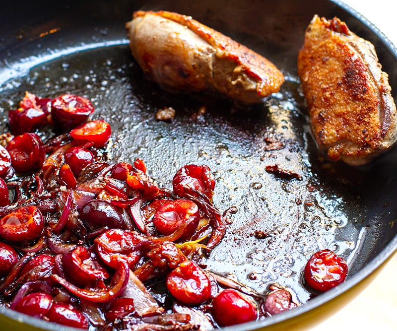 Duck and cherries in a pan