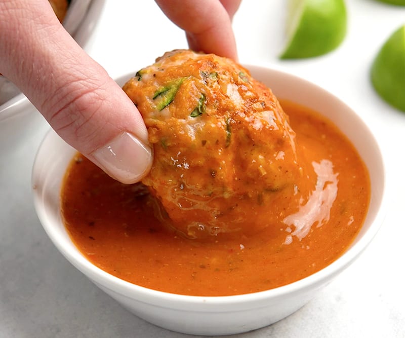 Dipping meatball into hot sauce