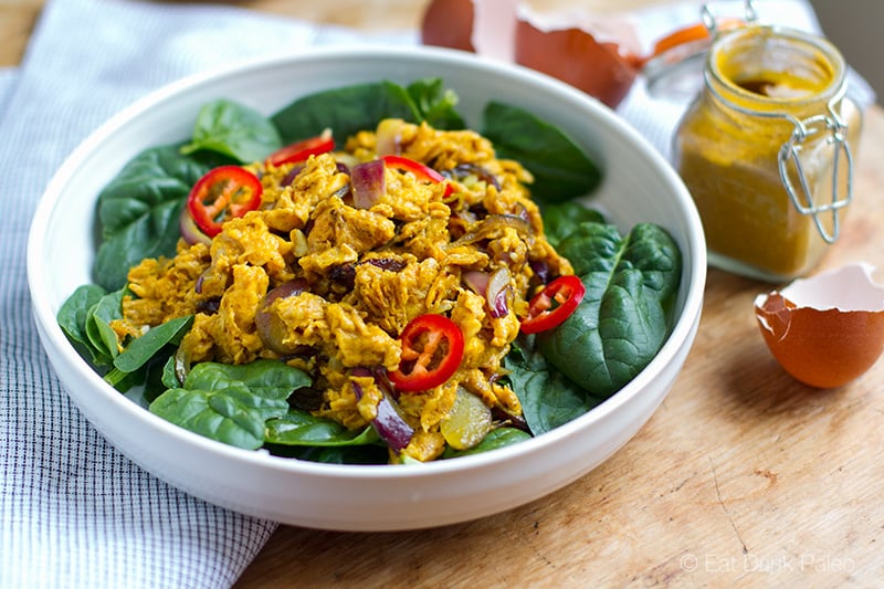 Curried Scrambled Eggs with onions on a bed of spinach.