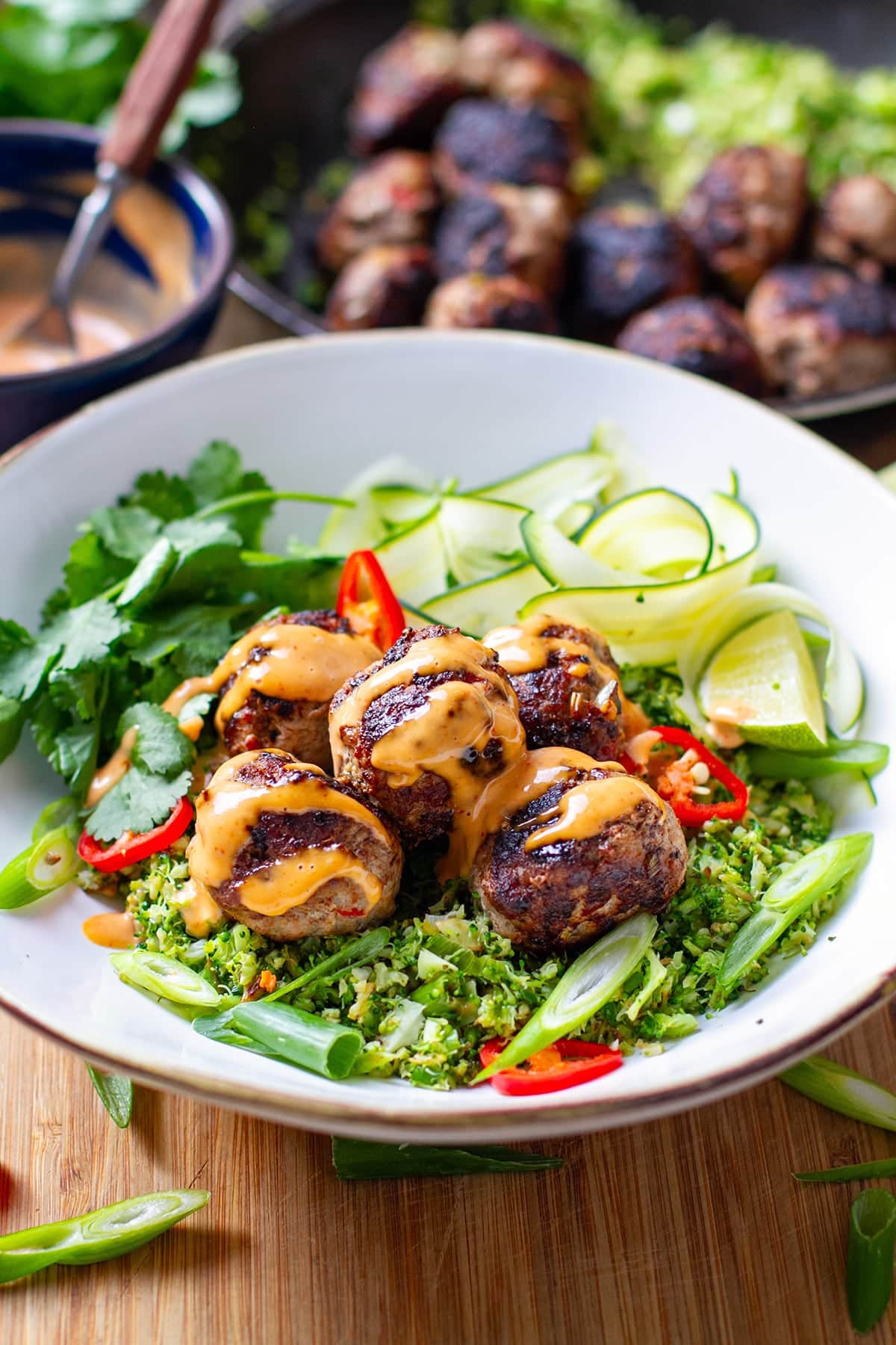 Vietnamese meatballs on a bed of broccoli rice with Sriracha mayo drizzle on top.