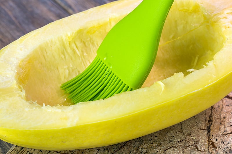 Brushing spaghetti squash with oil