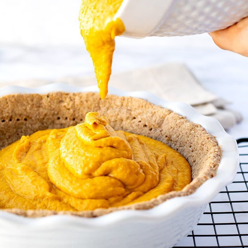 Paleo pumpkin filling going into pecan pie crust