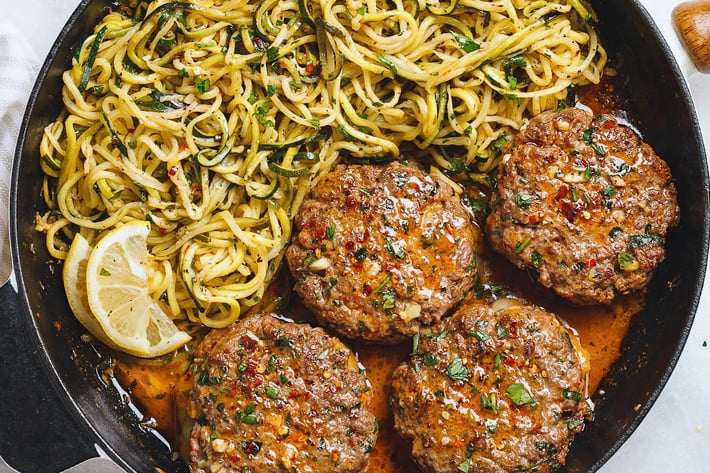 Low-carb skillet meal of cheesy beef burgers with zucchini noodles