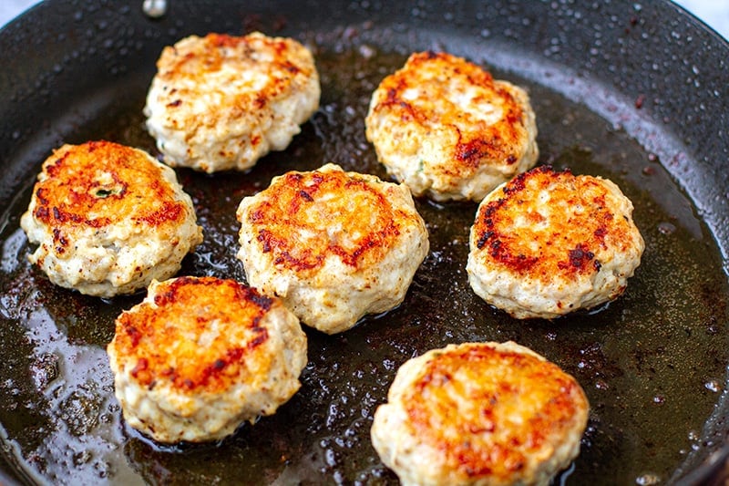 Pan frying chicken patties in a pan