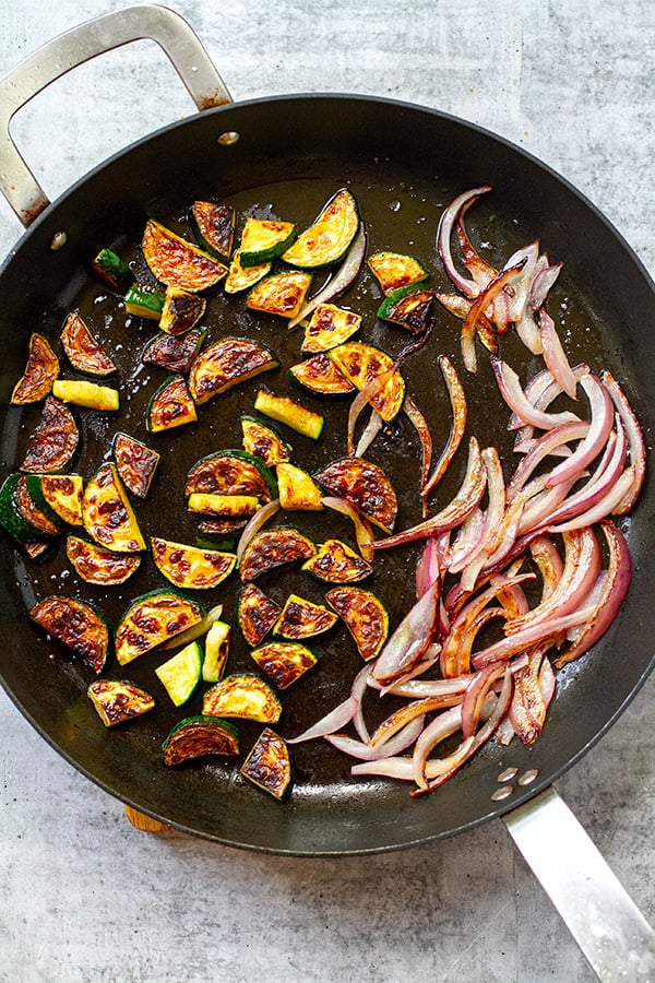 Pan frying zucchini and onions in a pan