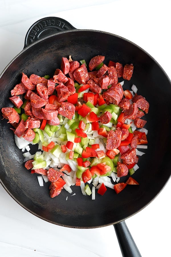 Pan frying chorizo with onions and peppers in a pan