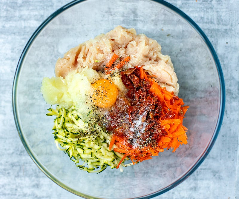 Chicken mince rissoles ingredients with grated vegetables and egg in a bowl