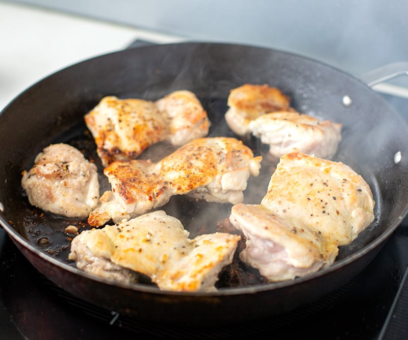 Pan-fried chicken thighs in a pan