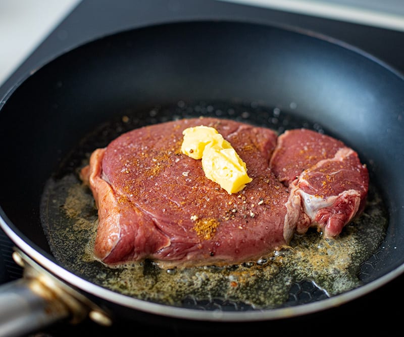 Grilling steak with butter on top