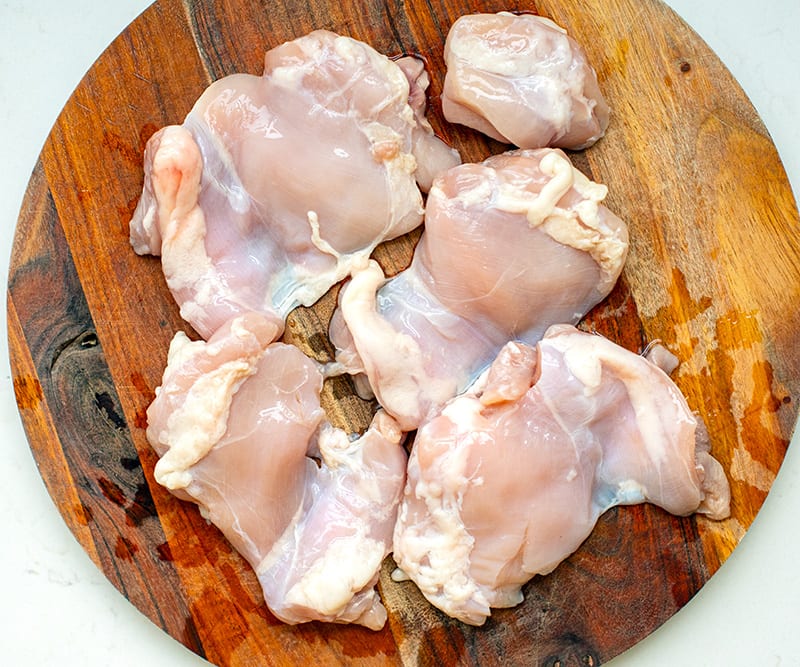 Chicken thighs on a chopping board