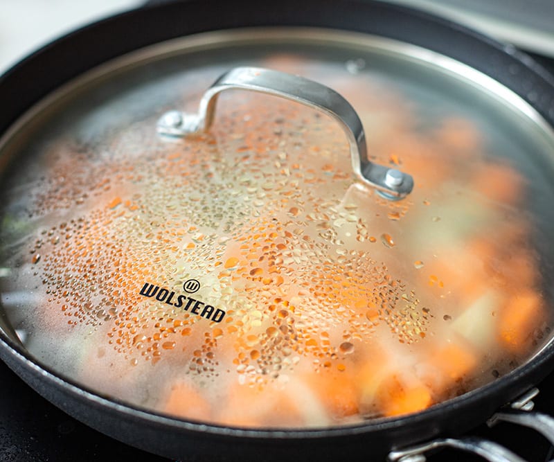 Cooking sweet potatoes and onions in a skillet
