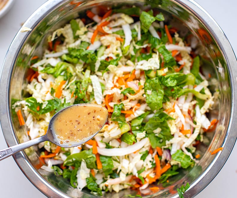 Wombok salad with chicken mixed in a bowl