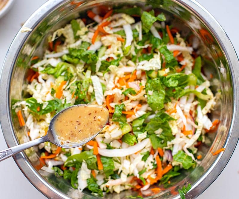 Wombok salad with chicken mixed in a bowl