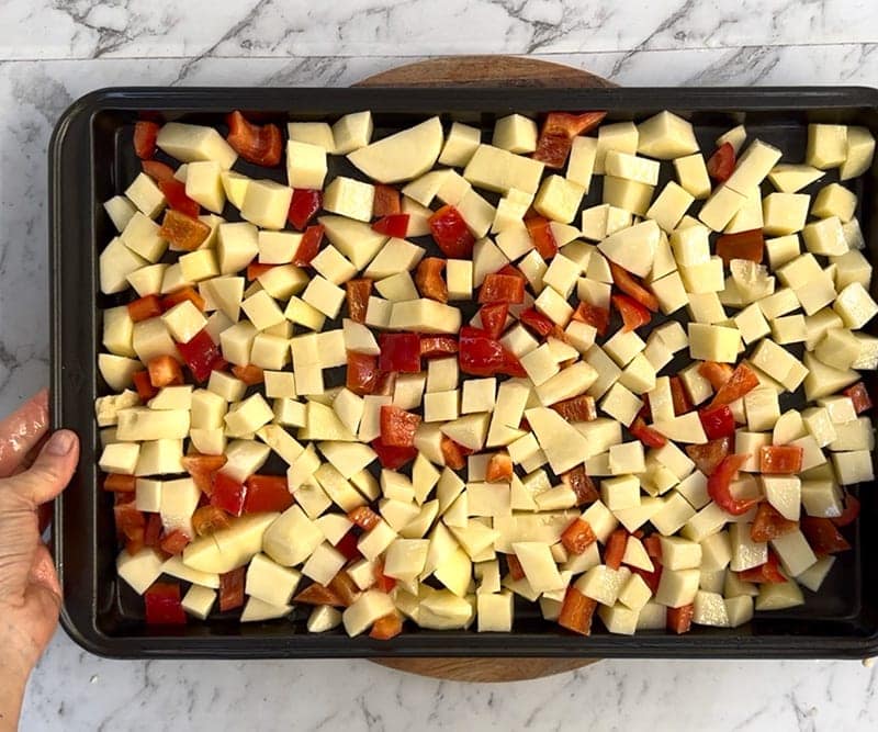 Spread potatoes and peppers on a sheet pan