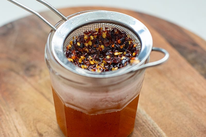 Strain honey through a sieve