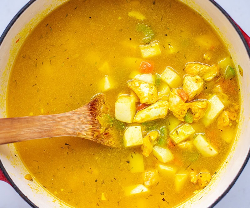 Stirring chicken and potatoes in a pot