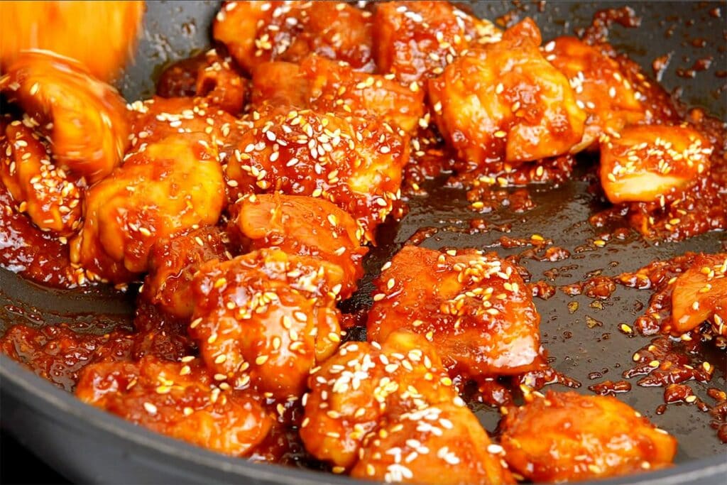 Spicy Korean chicken with sesame seeds in a pan