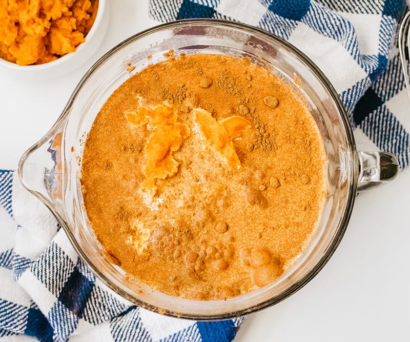 Add pumpkin cream and other ingredients to a bowl to make pumpkin bread pudding.