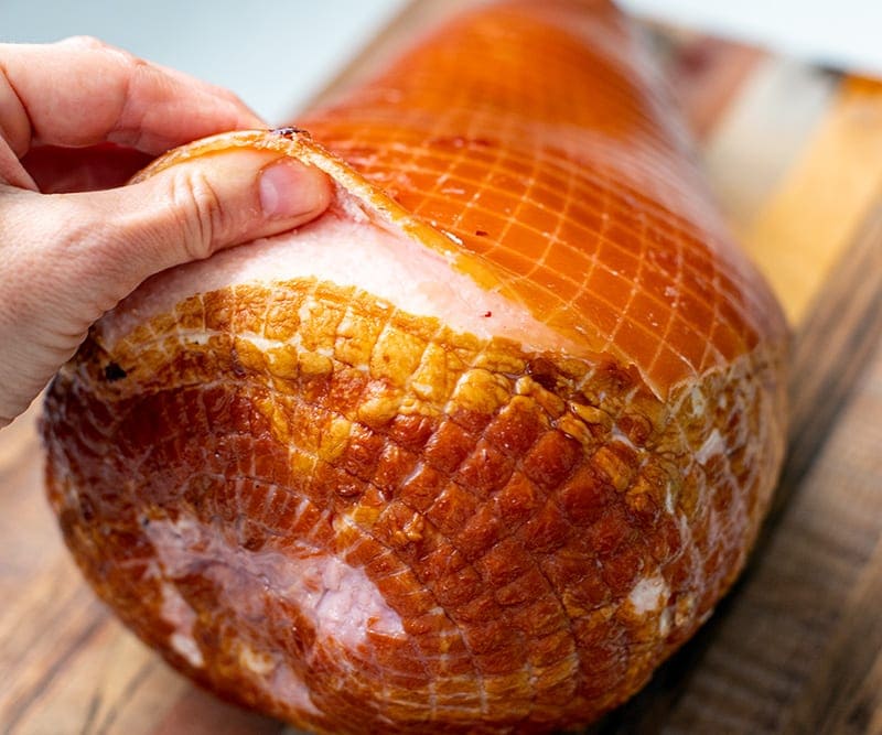 Run fingers under the ham's rind to remove it