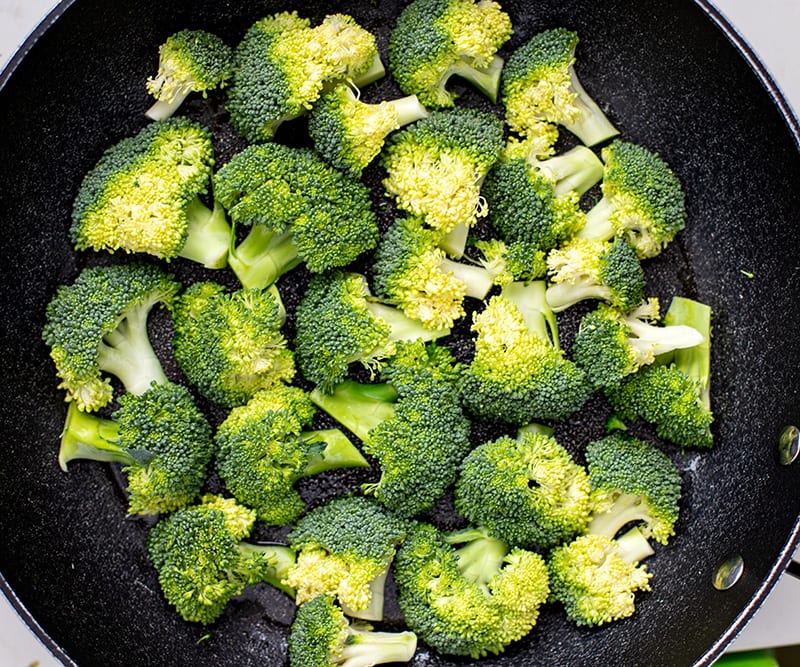 broccoli florets facing down un a frying pan