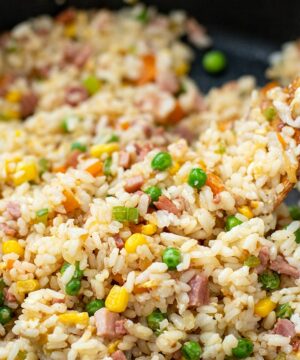 Ham fried rice with a spatula in a skillet