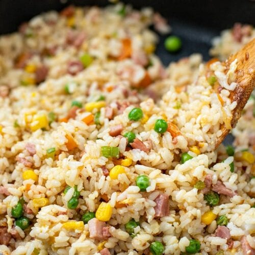 Ham fried rice with a spatula in a skillet