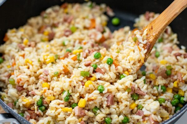 Ham fried rice with a spatula in a skillet