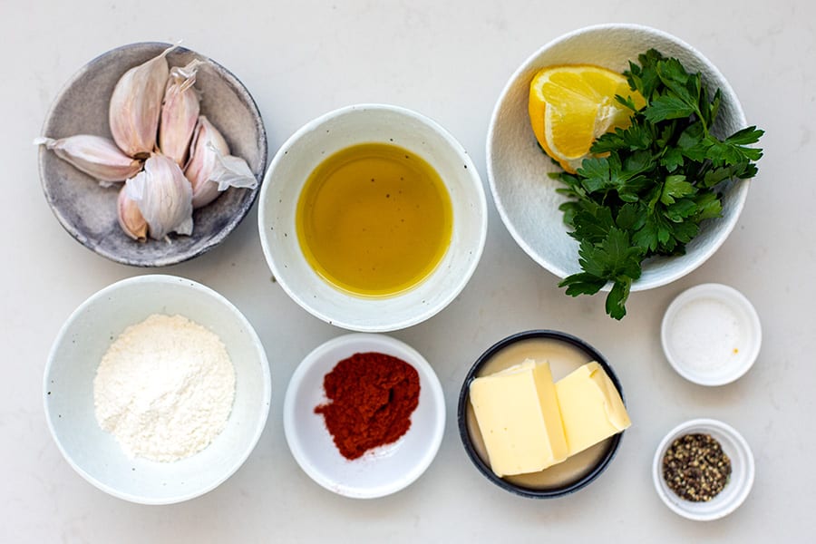 ingredients for garlic prawns: garlic, olive oil, butter, flour, paprika, salt, pepper, lemon and parsley