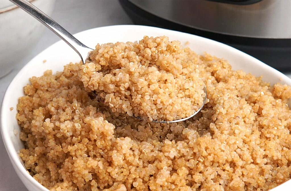 cooked quinoa in a bowl with a spoon. 