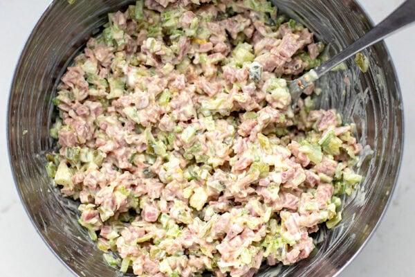 how to make ham salad - mixing everything with the dressing in a bowl.