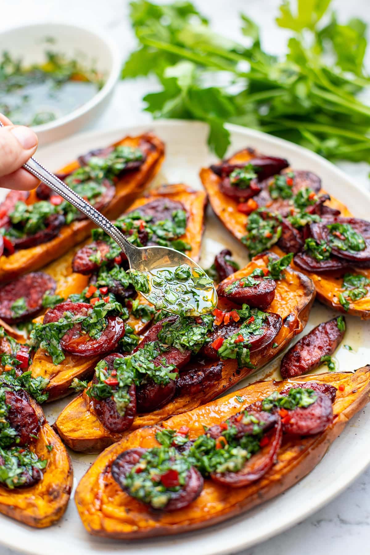 Chimichurri sauce over chorizo and roasted sweet potatoes