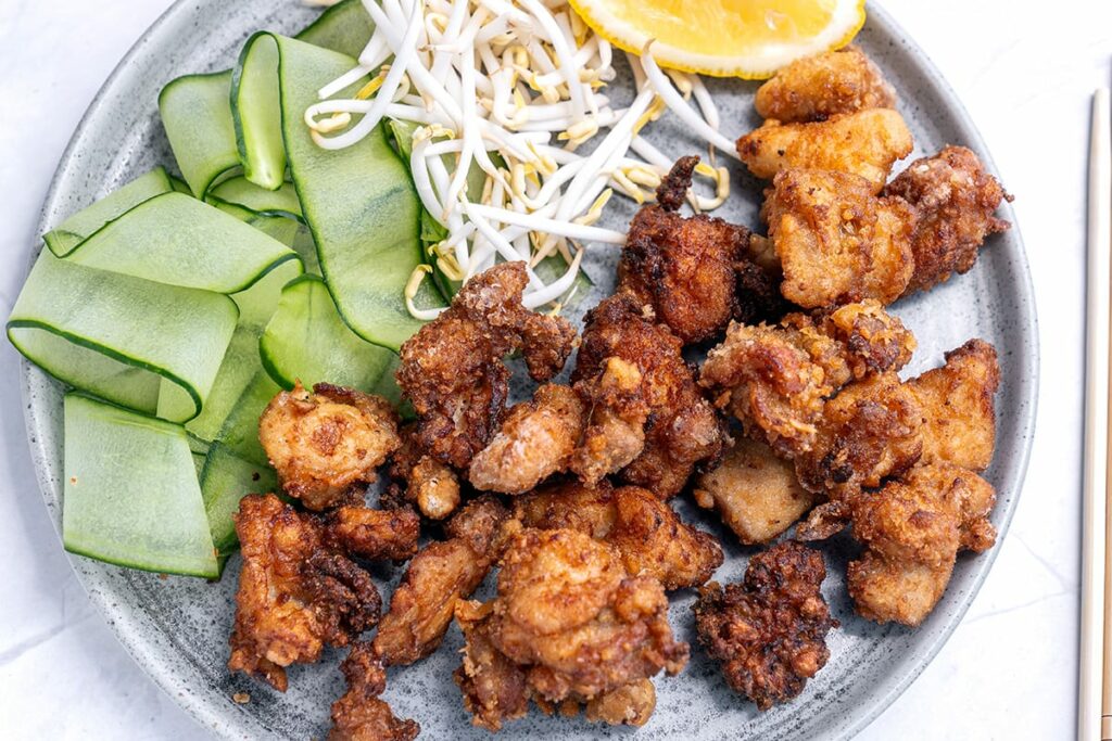 Karaage chicken on a plate with cucumber and sprouts
