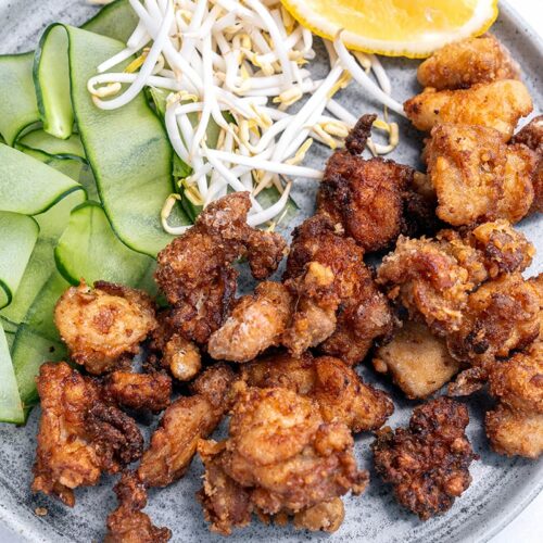 Karaage chicken on a plate with cucumber and sprouts