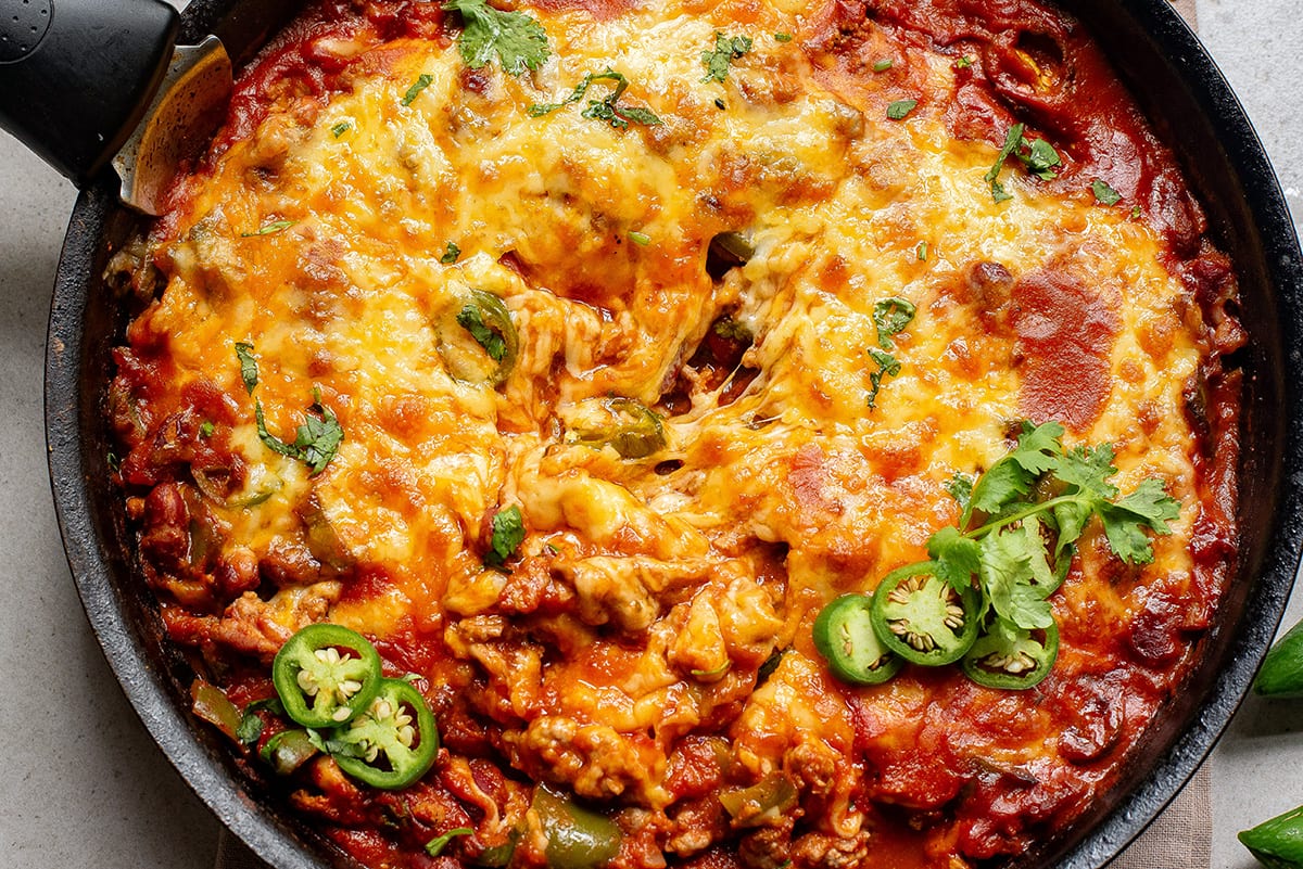 Mexican ground beef casserole with cheese in a skillet feature