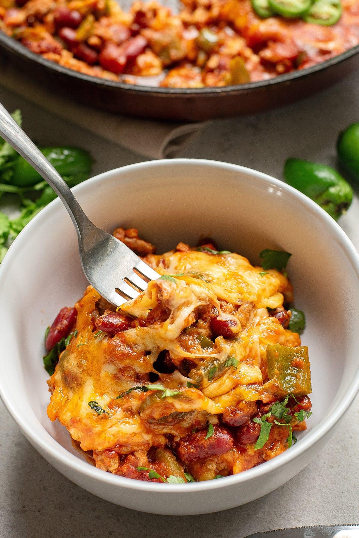 Mexican beef casserole with beans in a bowl with a fork