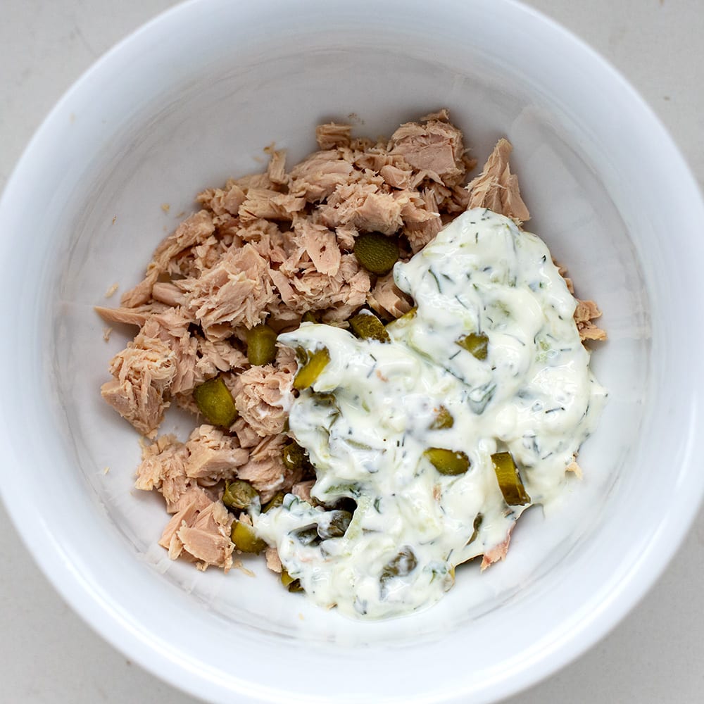 canned tuna in a bowl with mayonnaise, yoghurt, gherkins and capers