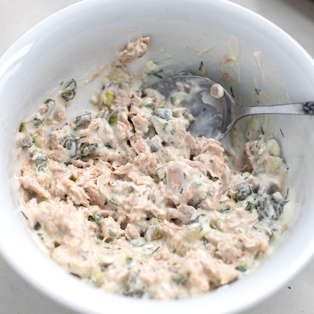 mixed canned tuna in a bowl with mayonnaise, yoghurt, gherkins and capers