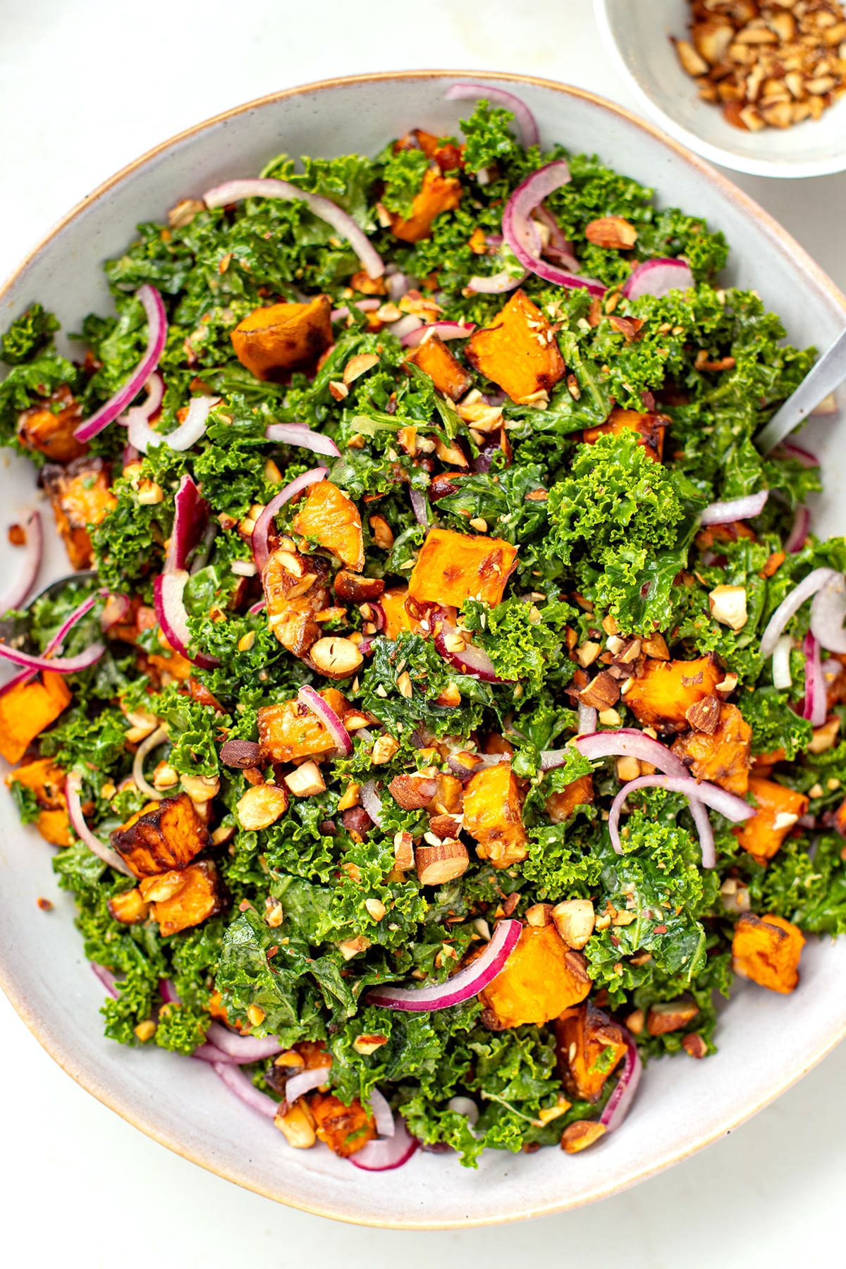 Kale salad with sweet potatoes, pickled onions, almonds and tahini dressing