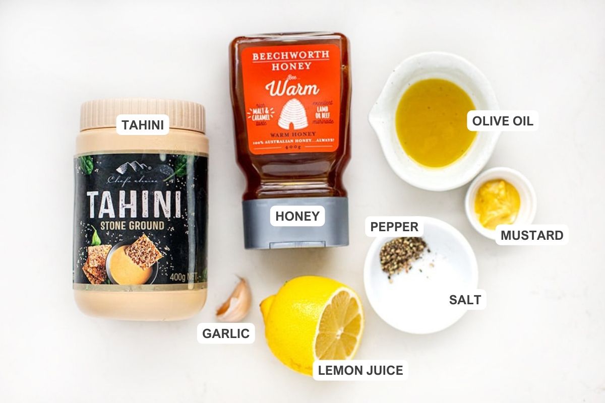 Kale salad dressing ingredients: tahini, lemon, honey, salt, pepper, garlic, mustard and olive oil.