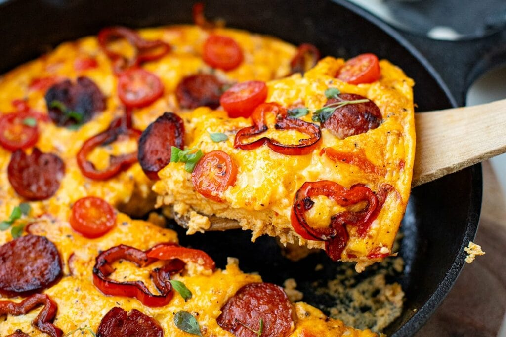 A slice of chorizo frittata on a wooden spatula