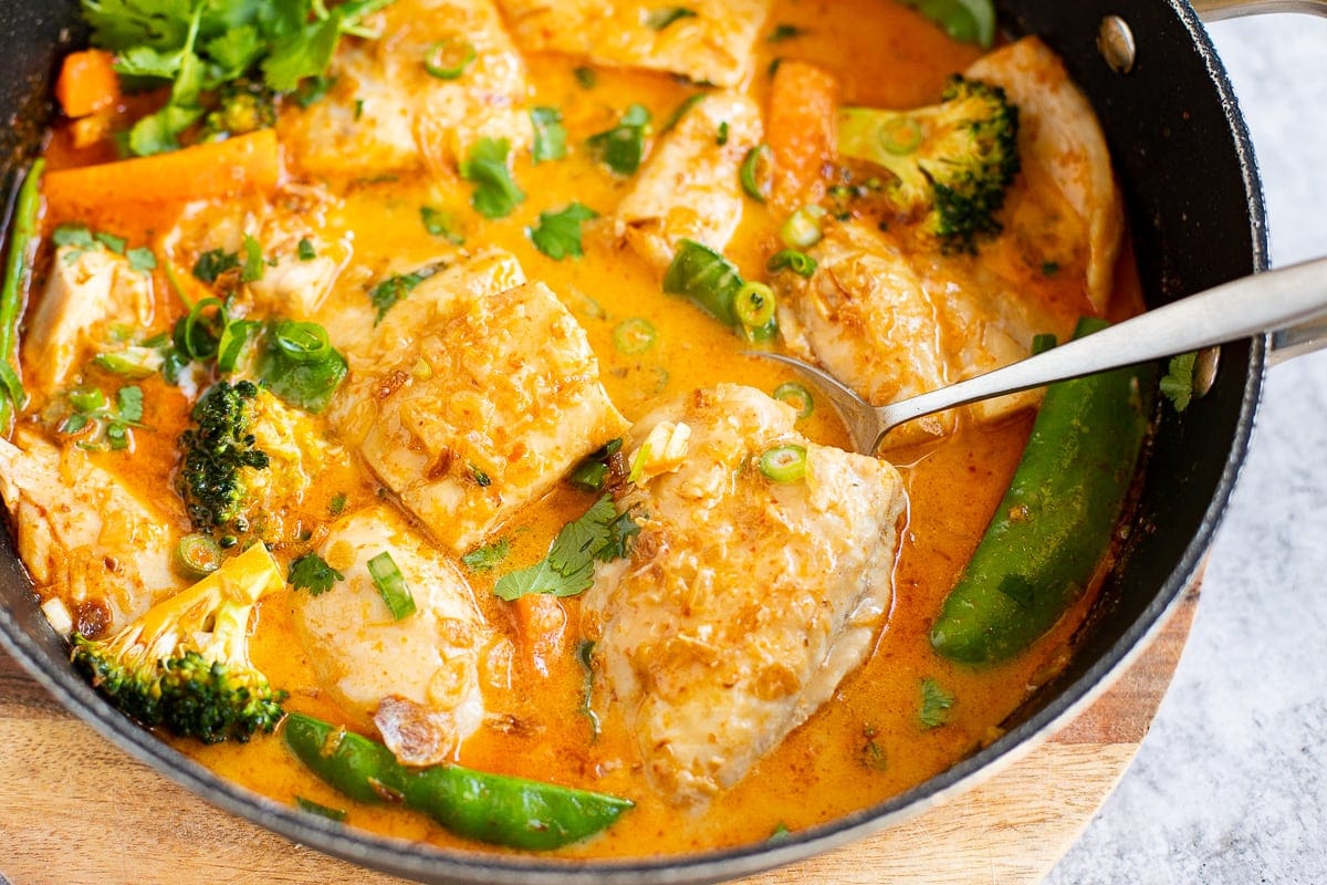Thai fish curry with snapper in red curry coconut sauce in a skillet