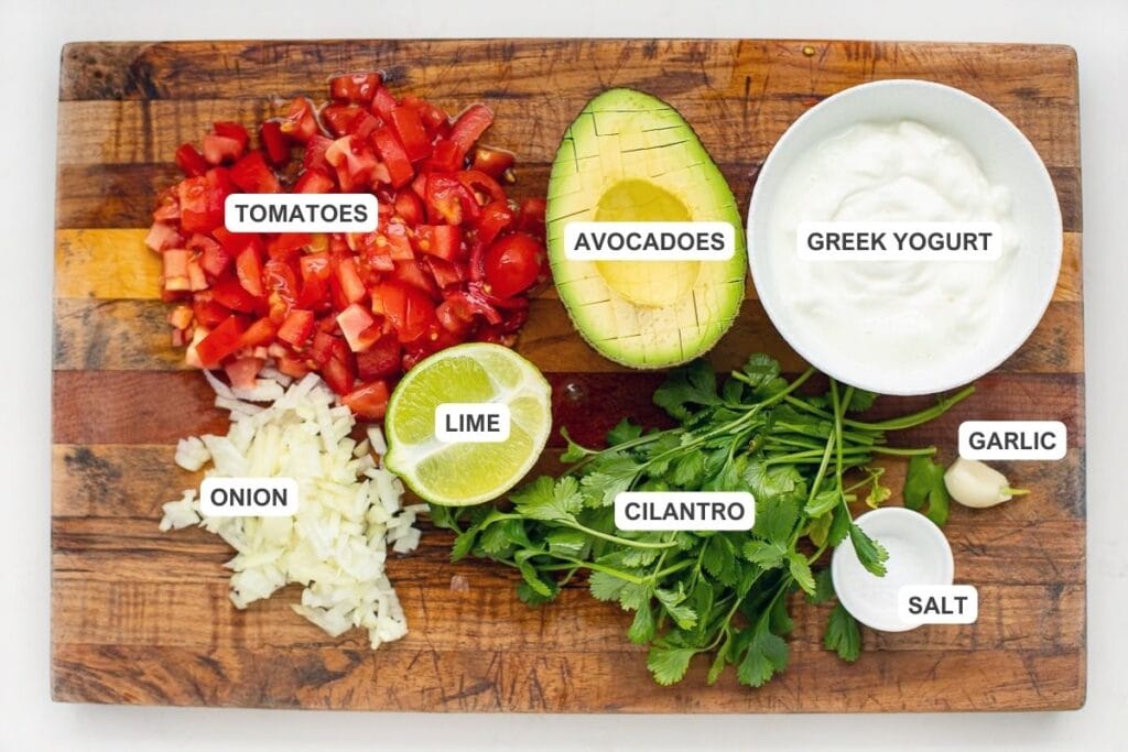 Ingredients for the salsa and cilantro yogurt sauce including avocado, tomatoes, onion, lime, salt, cilantro, garlic, and greek yogurt.