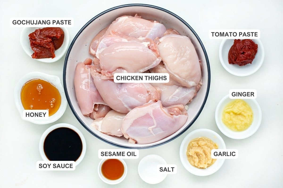 Ingredients for the recipe including chicken thighs, gochujang paste, tomato paste, honey, ginger, soy sauce, sesame oil, salt, and garlic.