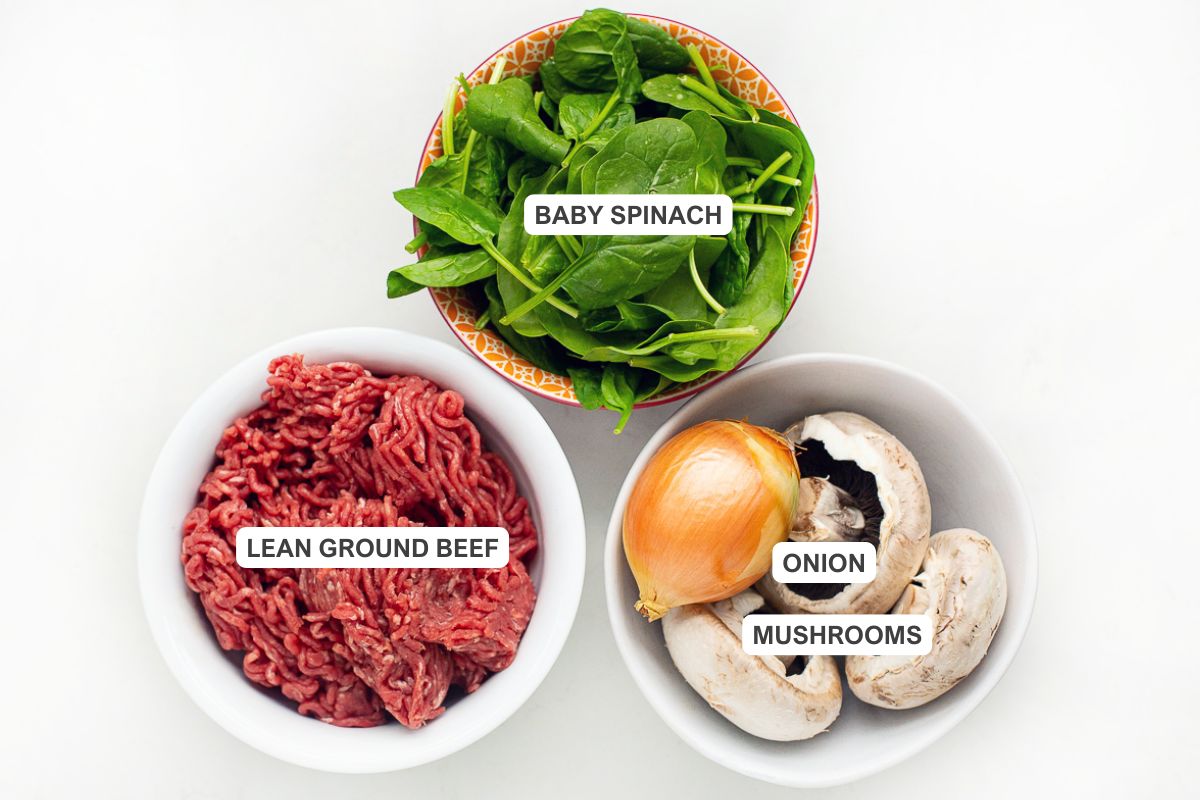 Ingredients for the recipe including lean ground beef, baby spinach, onion, and mushrooms.