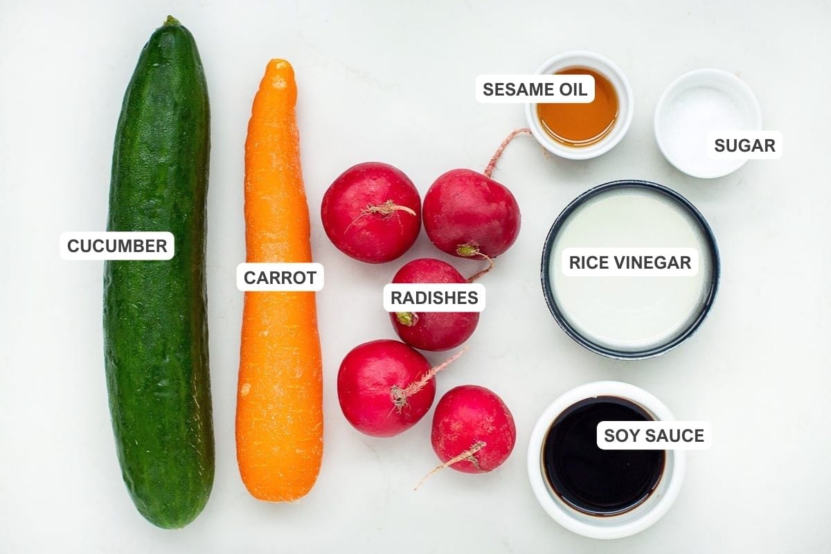 Ingredients for the recipe including cucumber, carrot, radishes, sesame oil, sugar, rice vinegar, and soy sauce.