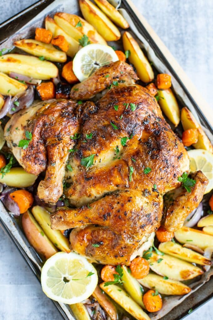 Butterflied chicken roasted with garlicky butter, potatoes and carrots.