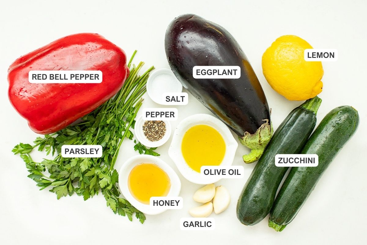 Ingredients for the recipe including lemon, eggplant, zucchini, red bell pepper, salt, pepper, olive oil, parsley, honey, and garlic.